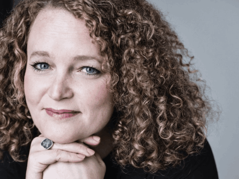 Lewy Body Society new ambassador Emma Cunniffe is pictured with hair in brown ringlets and resting her chin on her hands.