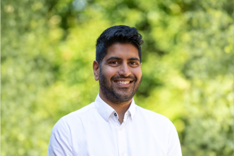 LBS funding: Man in white shirt against foliage background